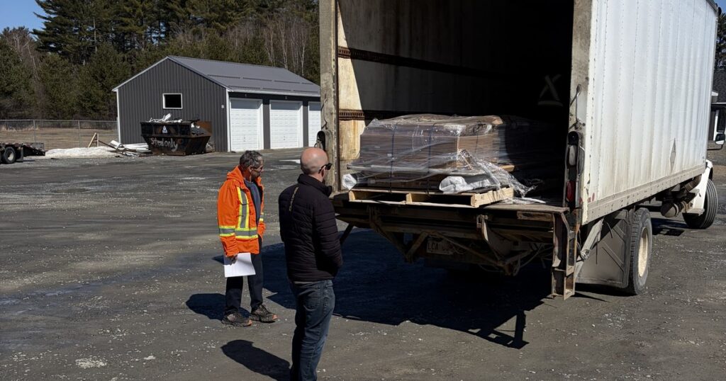 BluePrint Cabinets customer inspecting a shrink-wrapped cabinet pallet at curbside delivery