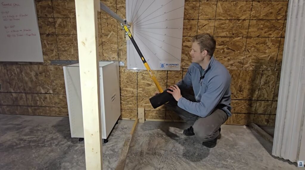 Pendulum rig with a 15-pound hammer and angle board used for the cabinet durability test